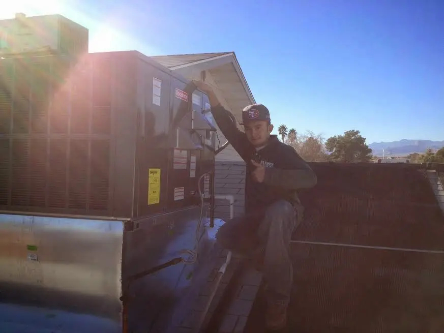 HVAC technician performing Air Duct Cleaning on a rooftop unit in Ocala